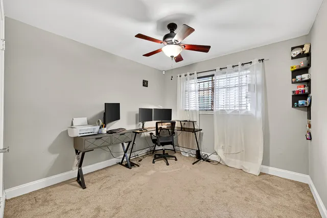 a view of a workspace with furniture and a window