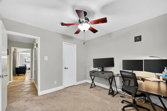 a view of a workspace with a window and a ceiling fan