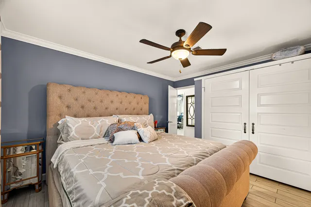a bedroom with a large bed and a ceiling fan