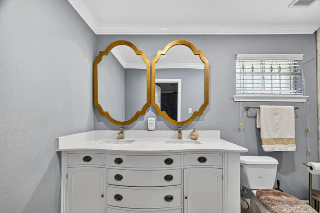 a bathroom with a sink mirror and a toilet