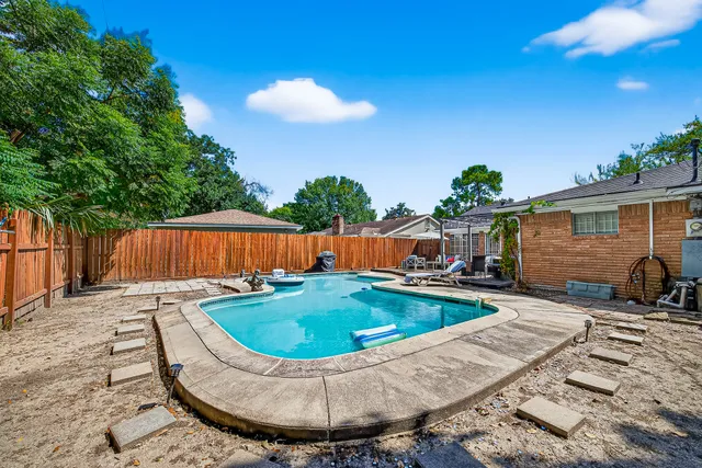 a view of a backyard with swimming pool