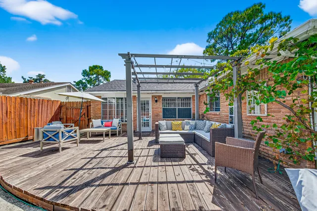 a view of a patio with couches table and chairs and potted plants