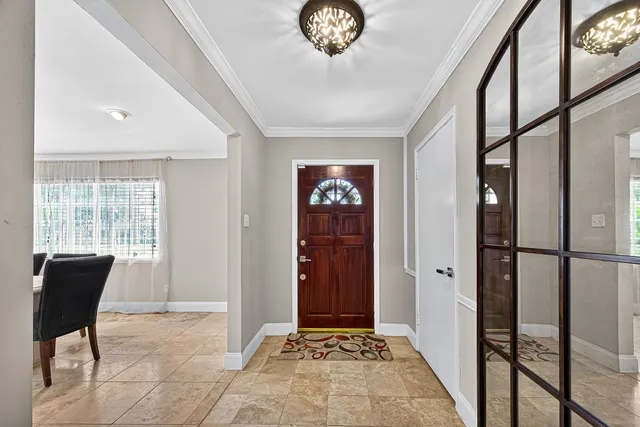 a view of a hallway with wooden floor and a dining room