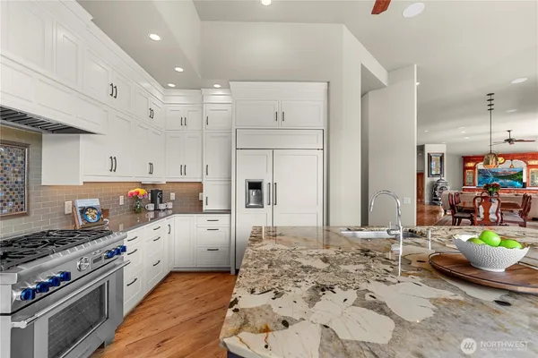 a large white kitchen with stainless steel appliances