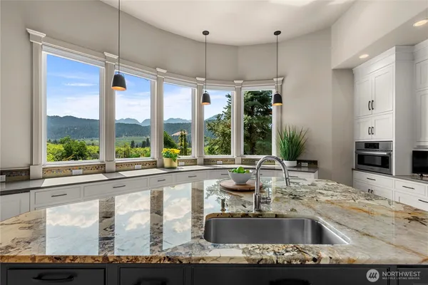 a kitchen with kitchen island a large window sink and cabinets