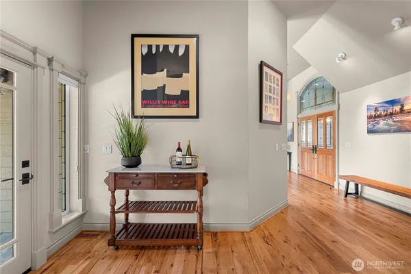 a view of a hallway with wooden floor and furniture