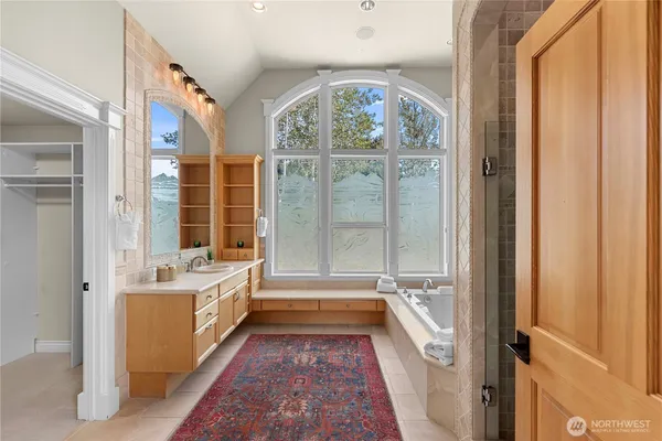 a bathroom with a tub sink and mirror