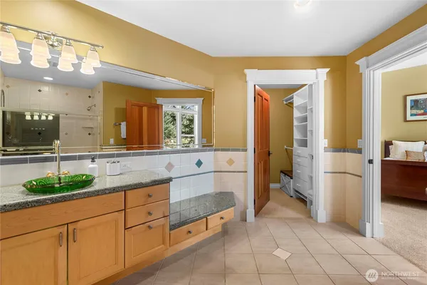 a spacious bathroom with a granite countertop sink and a mirror