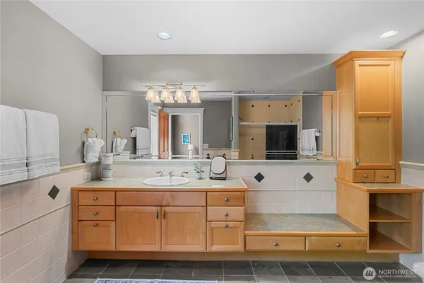 a spacious bathroom with a double vanity sink a mirror and shower