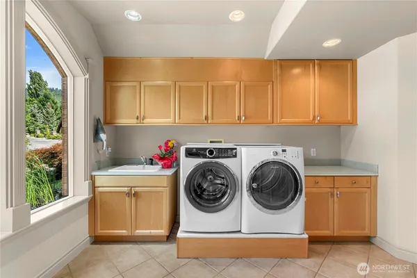 a utility room with sink dryer and washer