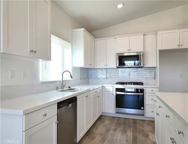 a large kitchen with stainless steel appliances kitchen island a large counter top and a stove top oven