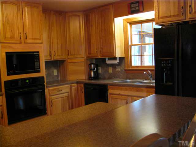 301 Pilot-Riley Road Zebulon, NC 27597 - Photo 6 of 15 a kitchen with stainless steel appliances granite countertop a stove a sink and a microwave