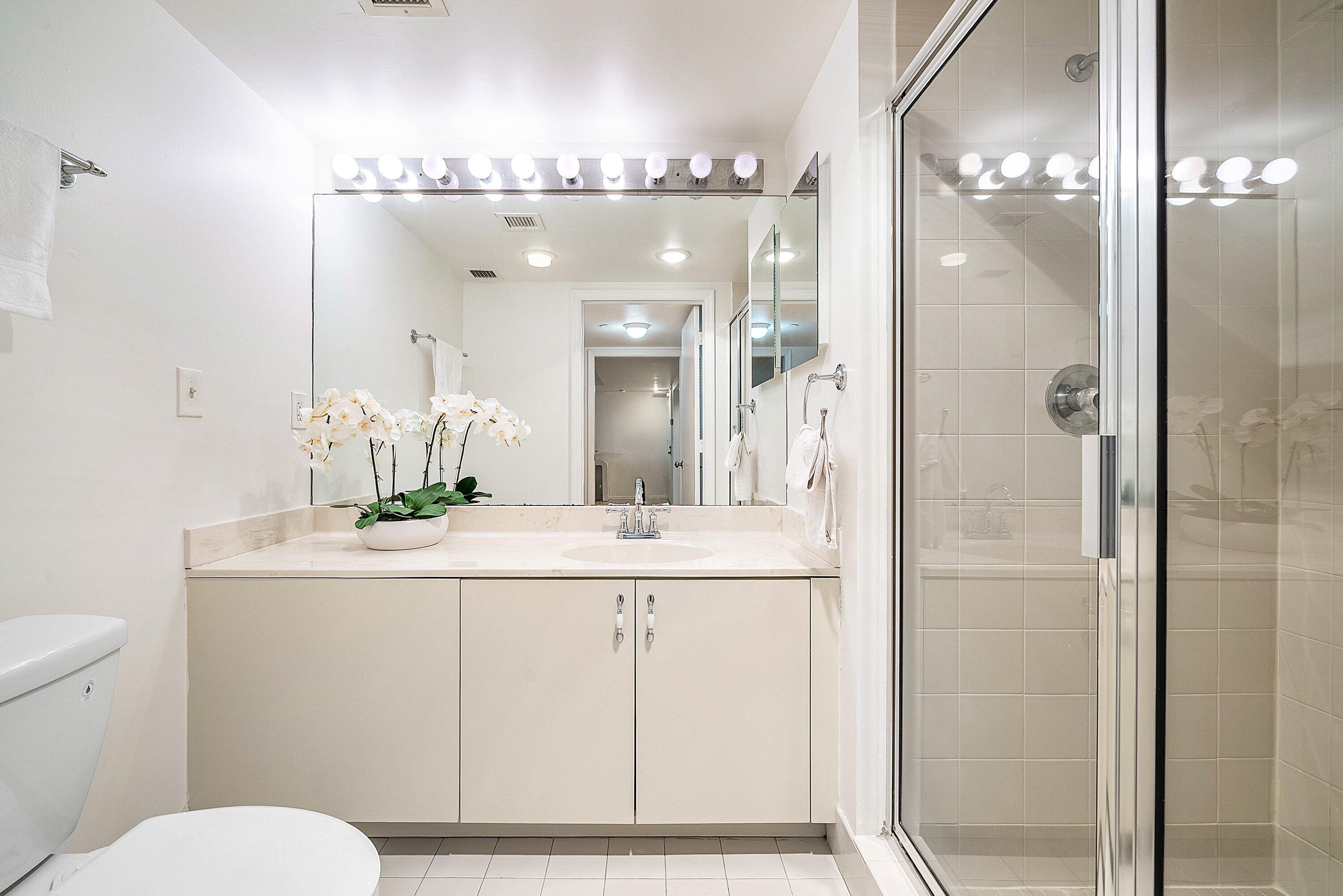 100 Southeast 5th Avenue, Unit 210 Boca Raton, FL 33432 - Photo 16 of 46 a bathroom with a sink a toilet a large mirror and shower
