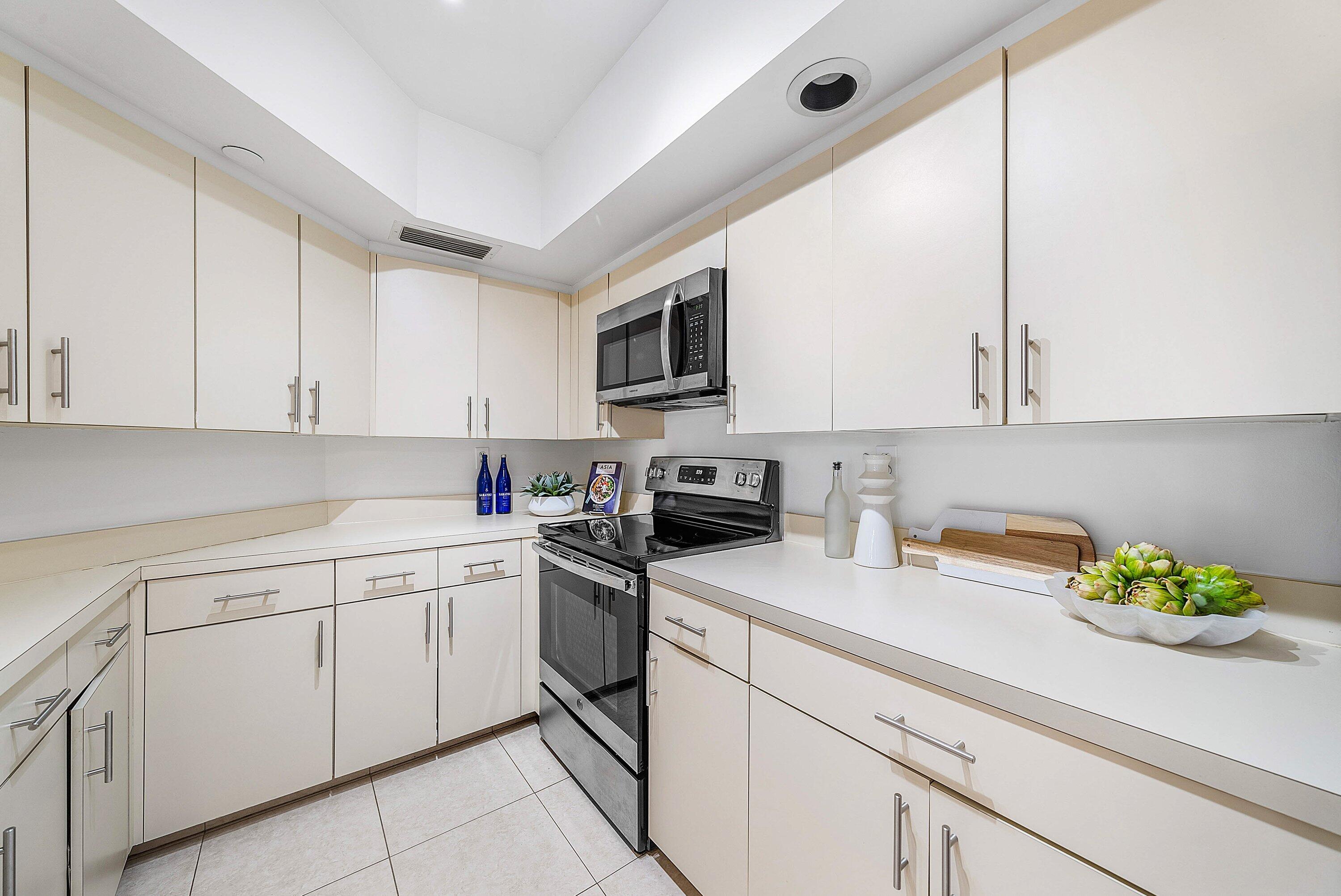 100 Southeast 5th Avenue, Unit 210 Boca Raton, FL 33432 - Photo 8 of 46 a kitchen with cabinets appliances a sink and a counter top