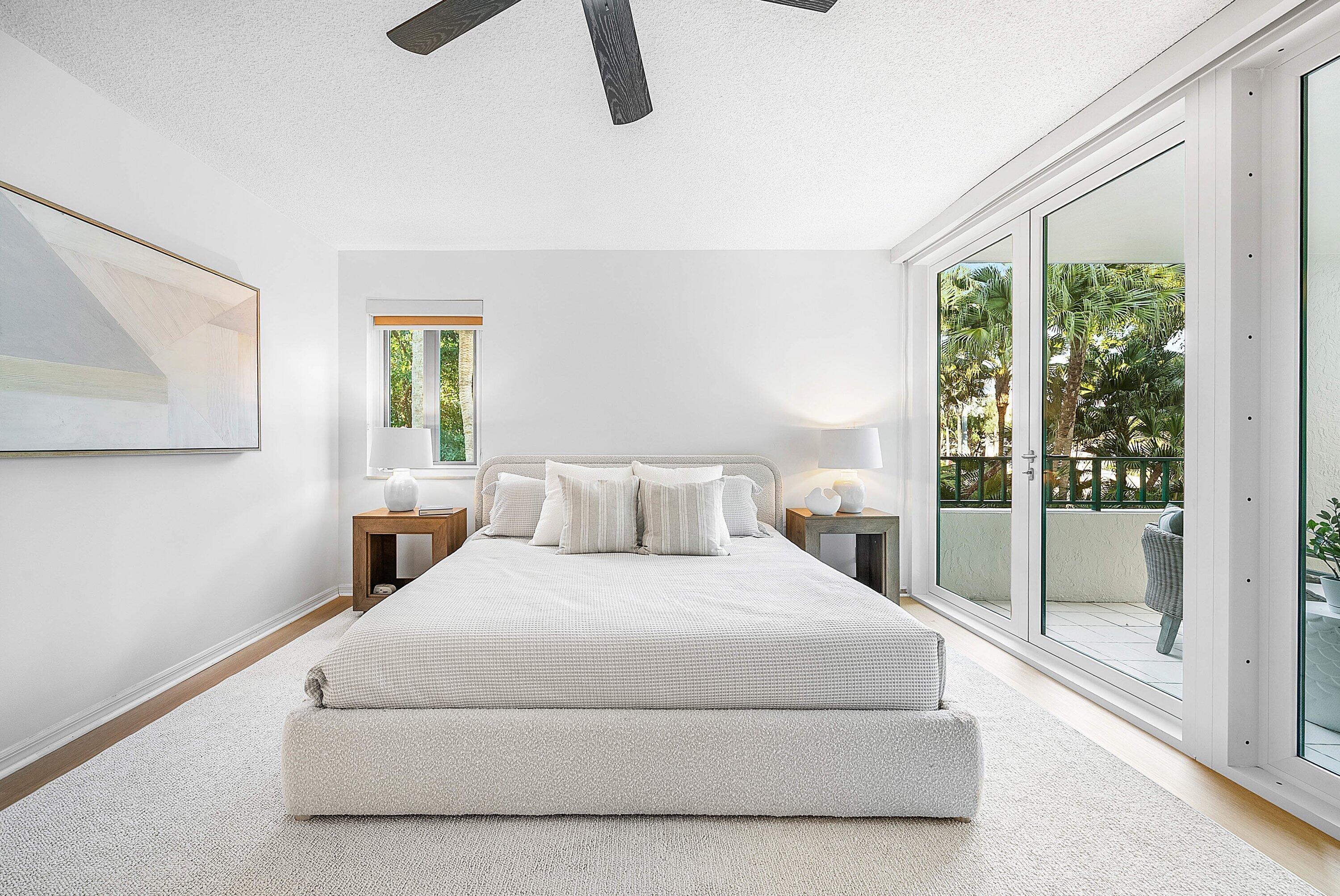 100 Southeast 5th Avenue, Unit 210 Boca Raton, FL 33432 - Photo 10 of 46 a bedroom with a large bed and a chandelier