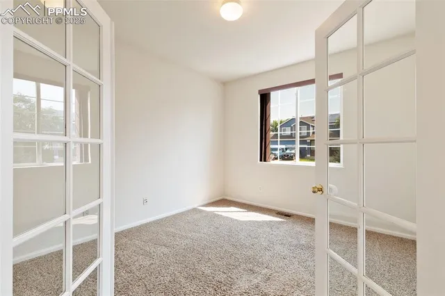 an empty room with closet and windows