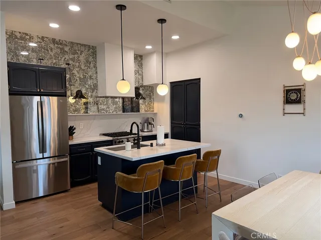 a kitchen with stainless steel appliances granite countertop a sink refrigerator and microwave