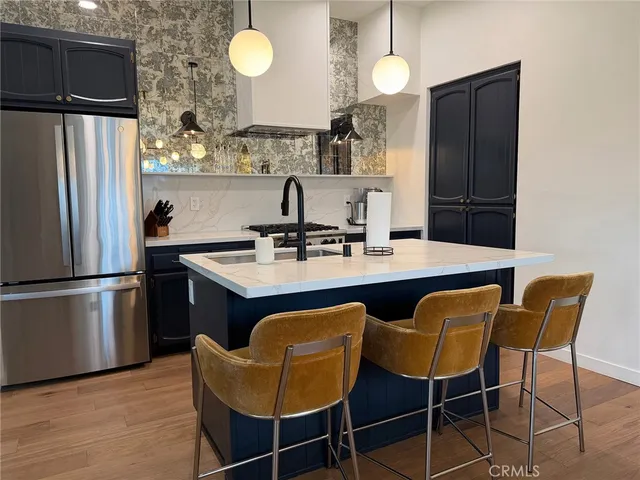 a kitchen with a dining table chairs and refrigerator
