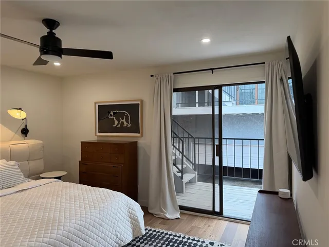 a bedroom with a bed and a flat tv screen on the dresser