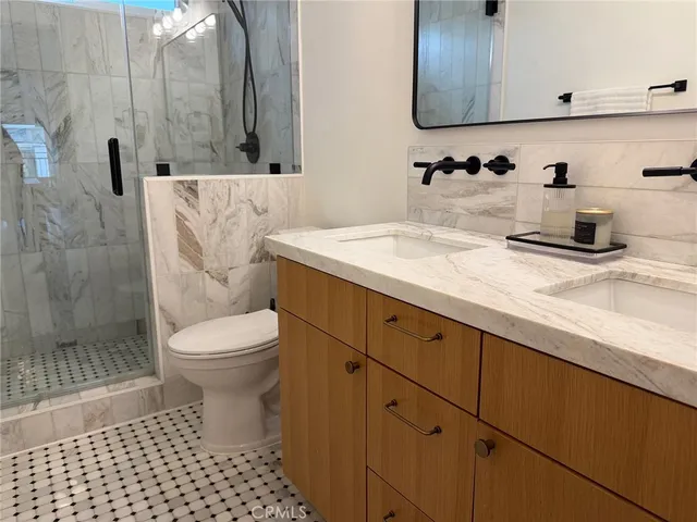 a bathroom with a sink a toilet and shower