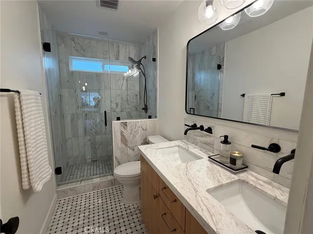 a bathroom with a sink a toilet and shower