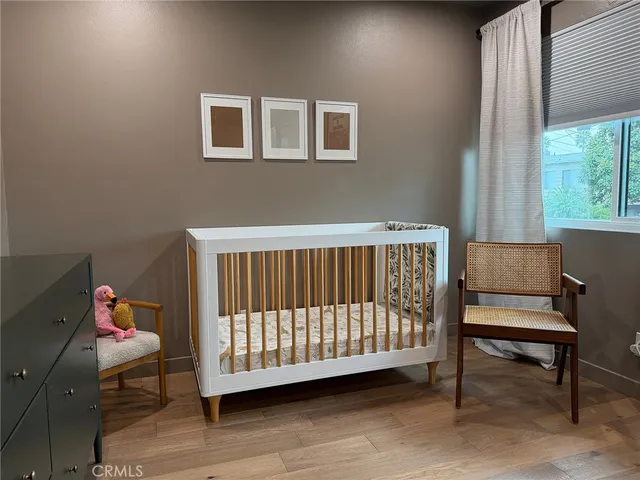 a bedroom with a baby bed a couch and a window