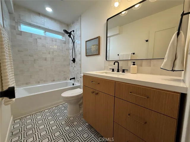 a bathroom with a double vanity sink toilet mirror and shower