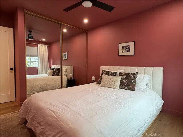 a bedroom with a large bed and a large mirror