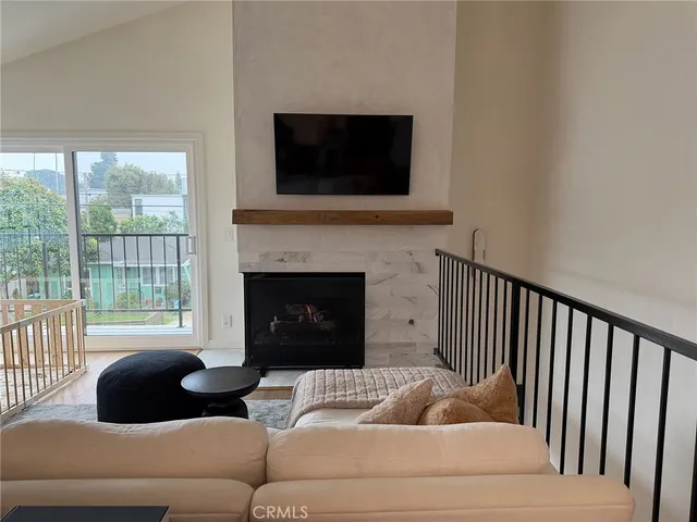 a living room with furniture a flat screen tv and a fireplace