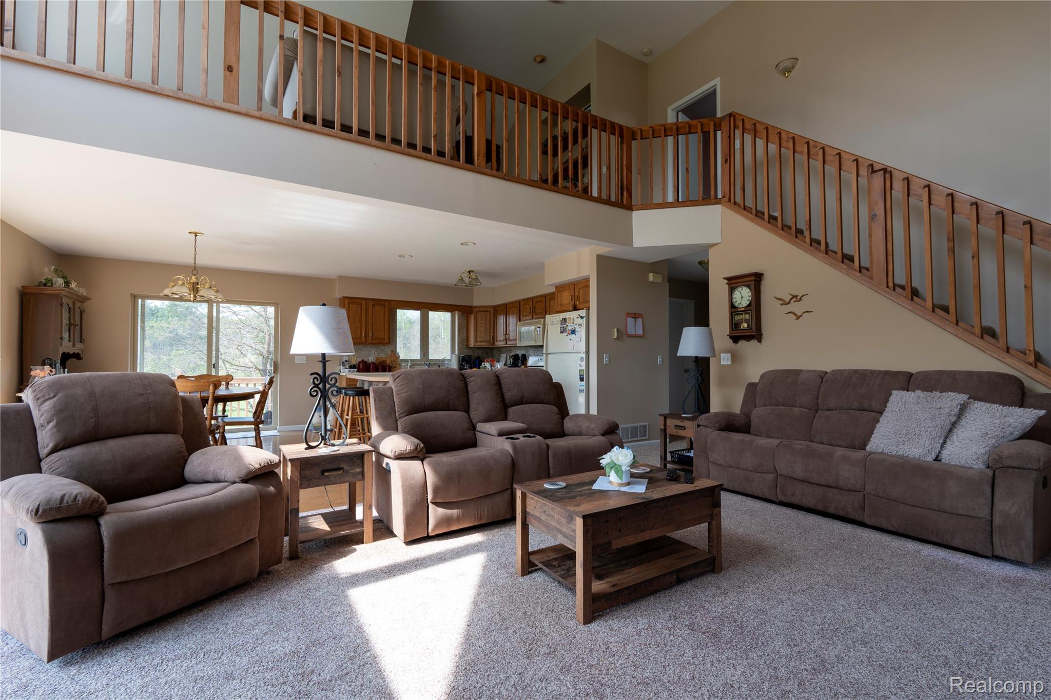4180 Sage Lake Road Lupton, MI 48635 - Photo 9 of 40 Living area featuring light carpet, hanging lights, and a high ceiling