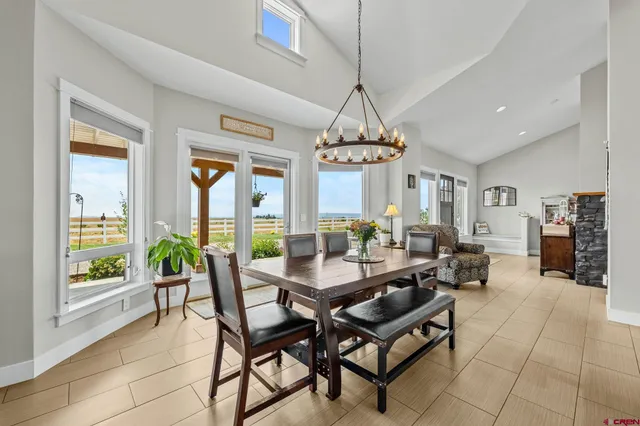 a dining room with furniture a chandelier and wooden floor