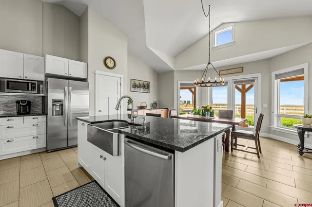 a kitchen with stainless steel appliances granite countertop a kitchen island a stove and a sink