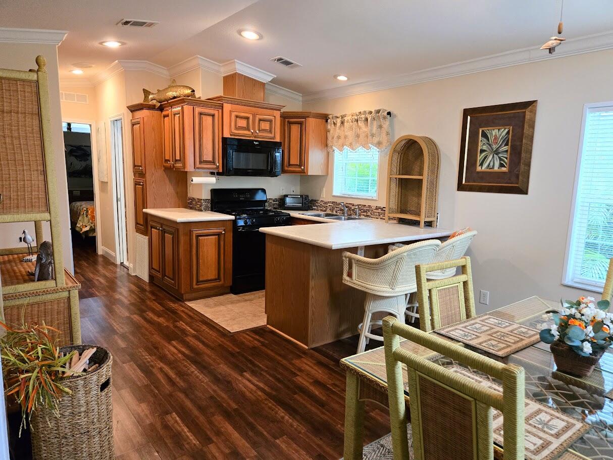 13680 Northwest 127th Terrace, Unit 17 Okeechobee, FL 34974 - Photo 11 of 30 a open kitchen with stainless steel appliances granite countertop a stove refrigerator and a sink