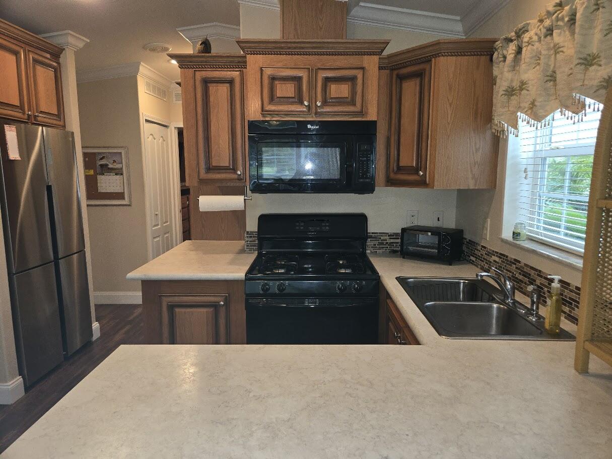 13680 Northwest 127th Terrace, Unit 17 Okeechobee, FL 34974 - Photo 12 of 30 a kitchen with granite countertop a refrigerator stove and sink