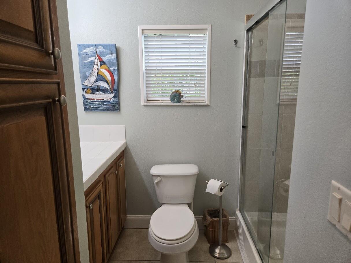 13680 Northwest 127th Terrace, Unit 17 Okeechobee, FL 34974 - Photo 23 of 30 a white toilet sitting next to a bathroom sink and a window