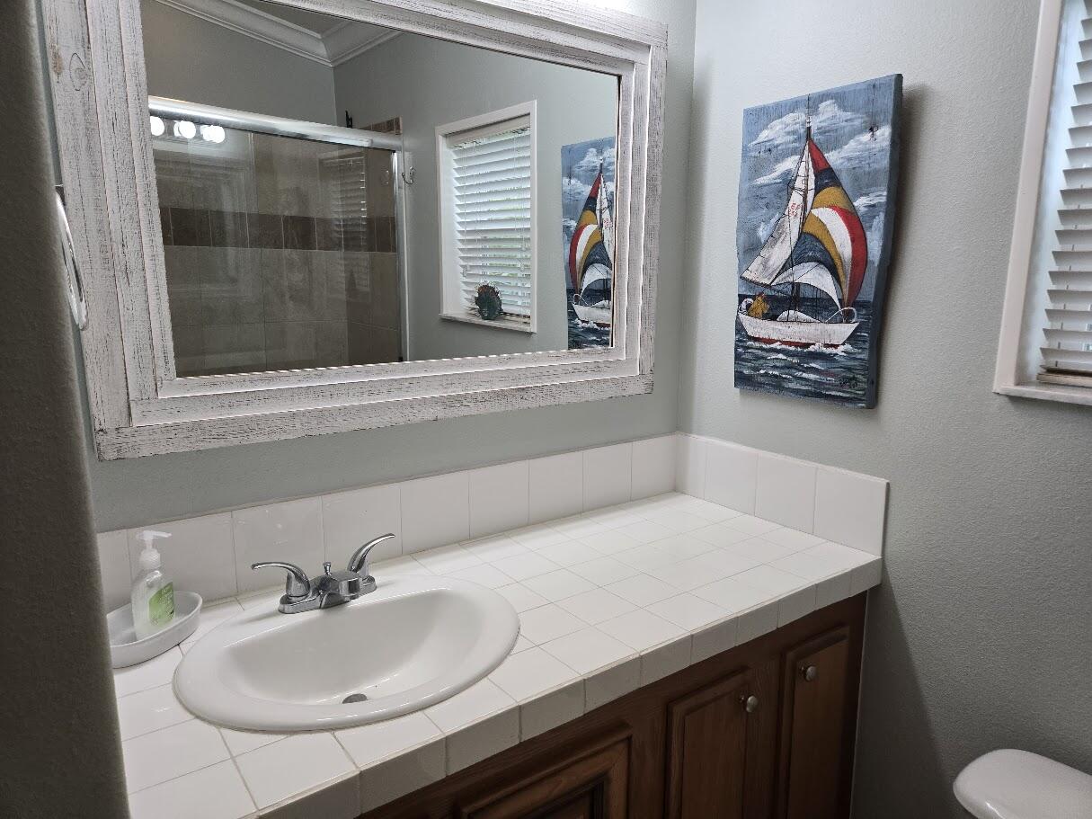 13680 Northwest 127th Terrace, Unit 17 Okeechobee, FL 34974 - Photo 24 of 30 a bathroom with a sink and a mirror