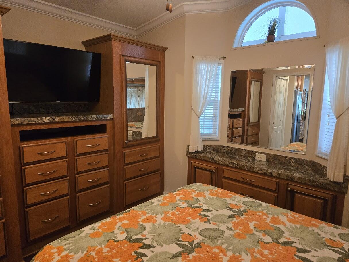 13680 Northwest 127th Terrace, Unit 17 Okeechobee, FL 34974 - Photo 27 of 30 a kitchen with a stove and a flat screen tv