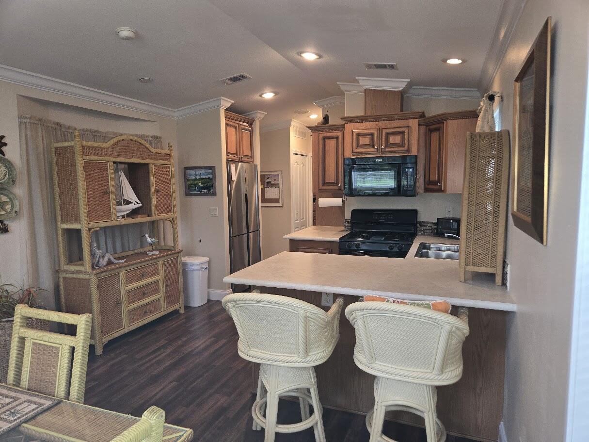 13680 Northwest 127th Terrace, Unit 17 Okeechobee, FL 34974 - Photo 10 of 30 a kitchen with stainless steel appliances granite countertop a sink and a refrigerator