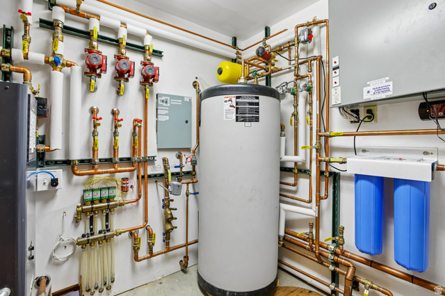 10205 East Moose Loop Road Salt Lake City, UT 84121 - Photo 34 of 50 Central water heater system with extensive copper piping, multiple pumps, and a dual-stage water filtration unit