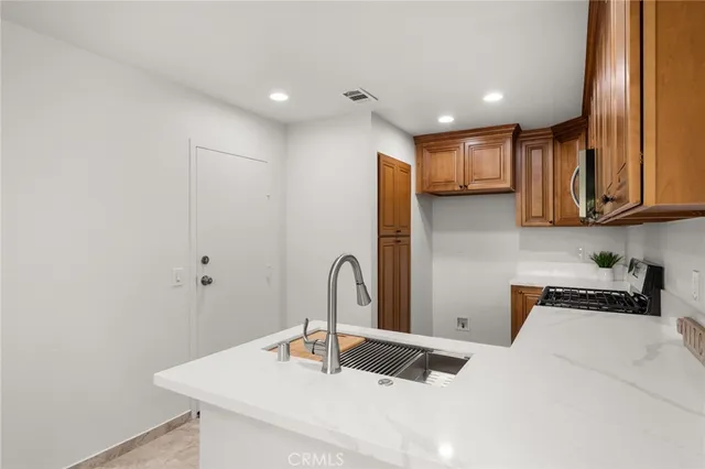 a kitchen with kitchen island a sink a stove and a refrigerator