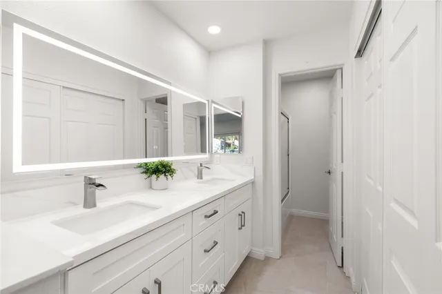 a bathroom with a toilet a sink a mirror a vanity and shower