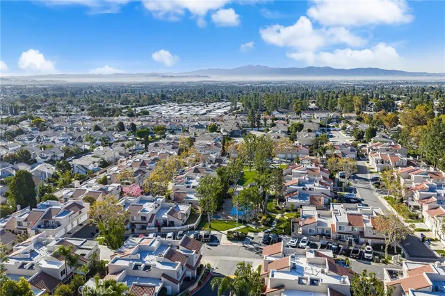 a view of swimming pool with lawn chairs and large trees