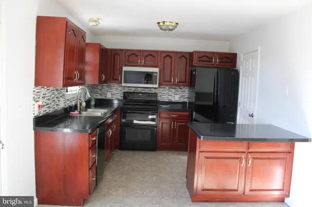 a kitchen with stainless steel appliances granite countertop a stove top oven microwave and refrigerator
