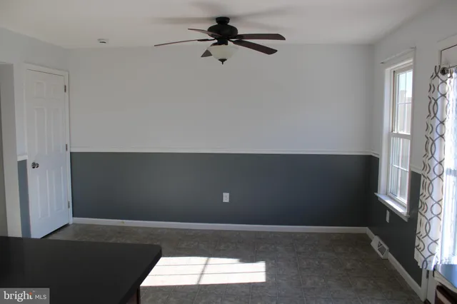 a view of a room with a ceiling fan and a window