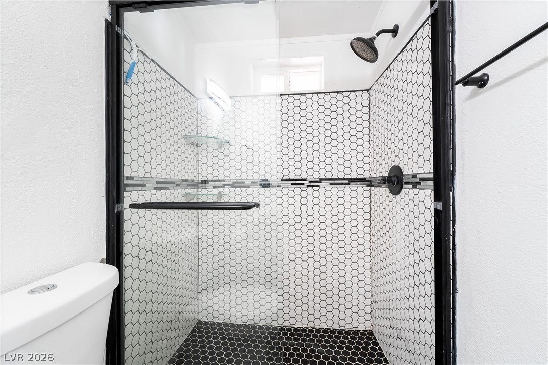 1551 West Wilson Road Pahrump, NV 89048 - Photo 30 of 68 Distinctive honeycomb tile work creates a crisp geometric backdrop in this modern walk-in shower.