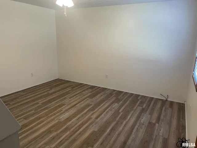 a view of a room with wooden floor and fan