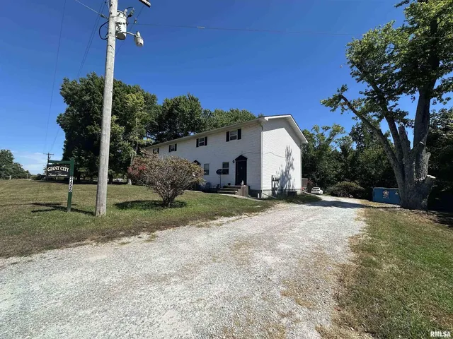 a view of a house with backyard and a tree