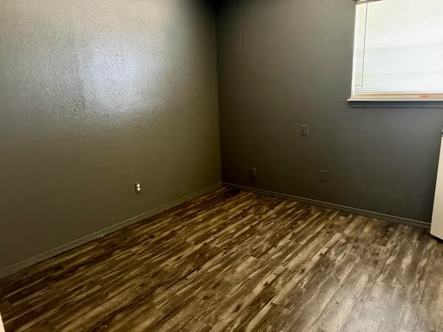 a view of a room with wooden floor and a window