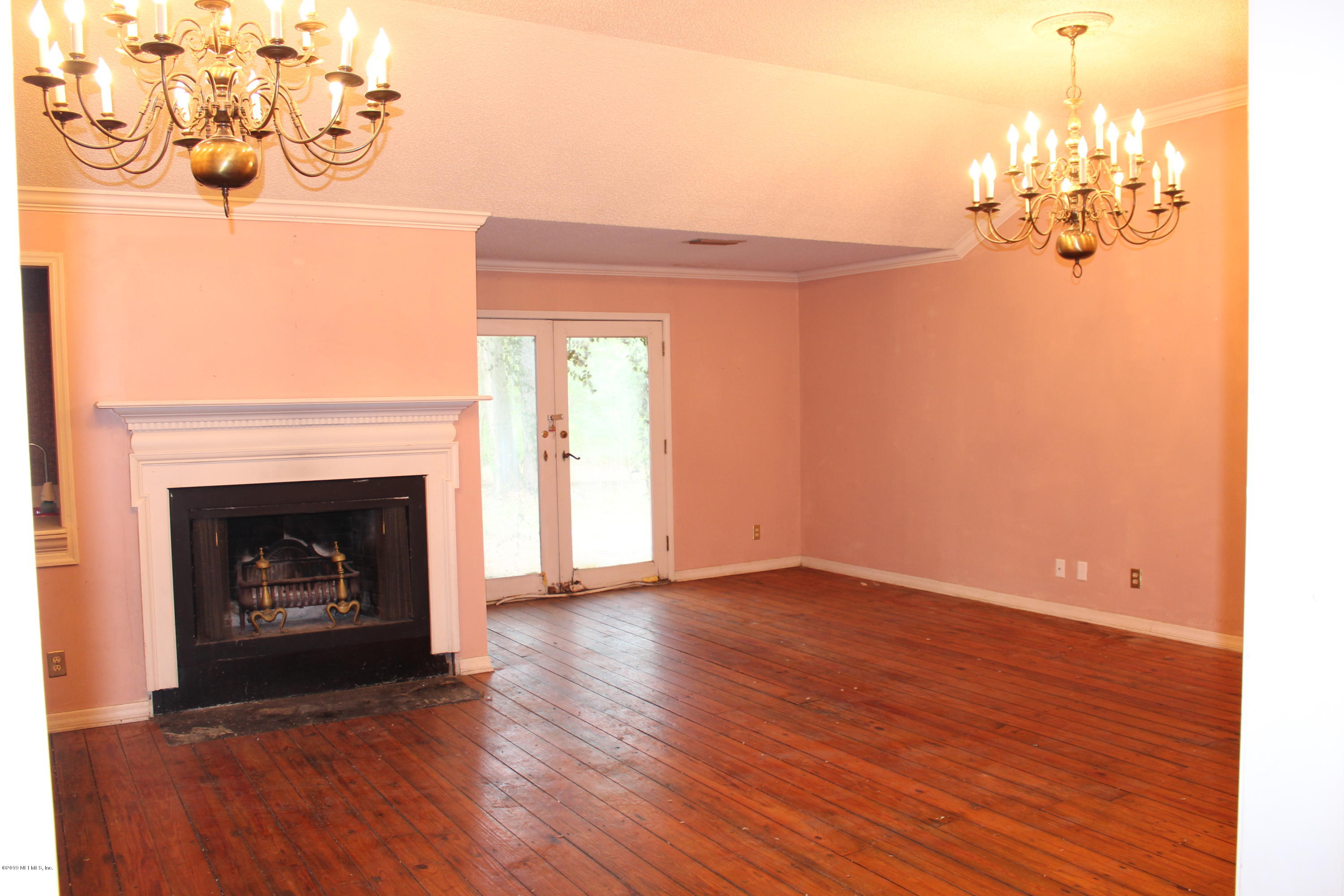9656 Wexford Road Jacksonville, FL 32257 - Photo 2 of 18 a view of a livingroom with a fireplace wooden floor and chandelier