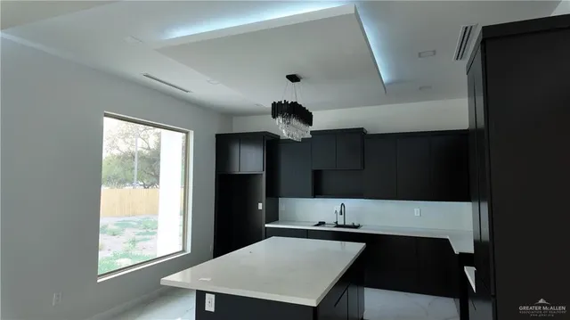 a kitchen with a table chairs refrigerator and sink